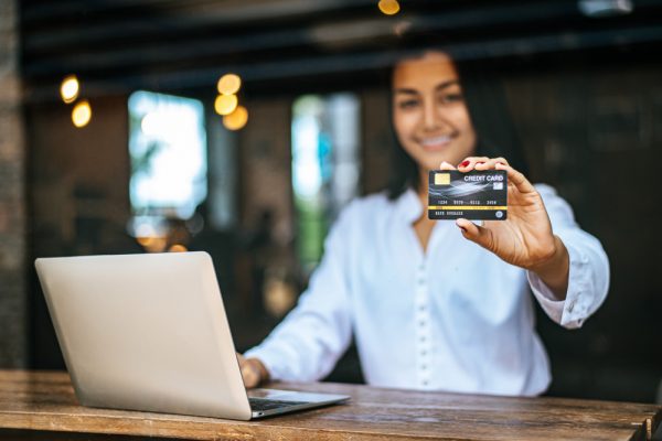 woman-sat-with-laptop-paid-with-credit-card-cafe